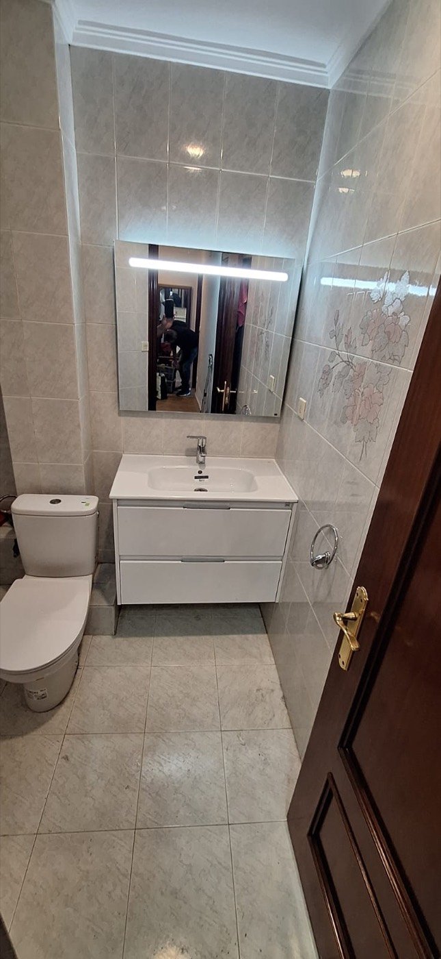 Baño reformado con espejo LED y mueble nuevo
